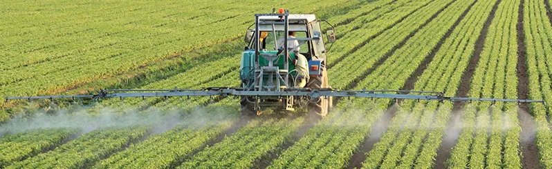 Person in tractor watering crops