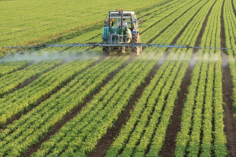 Person in tractor watering crops